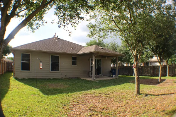 a view of a house with a yard and tree s