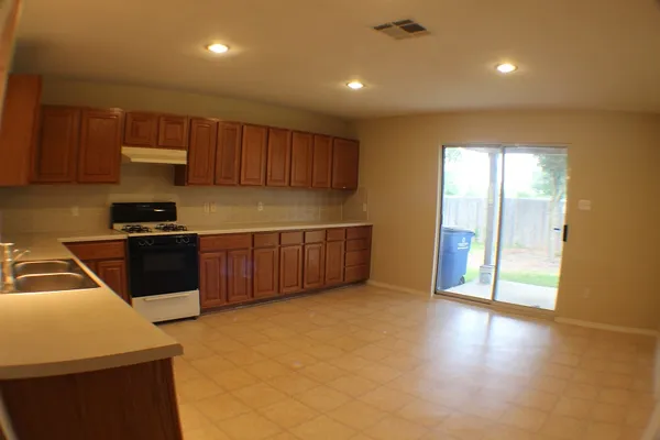 a kitchen with stainless steel appliances granite countertop a stove a sink and a refrigerator