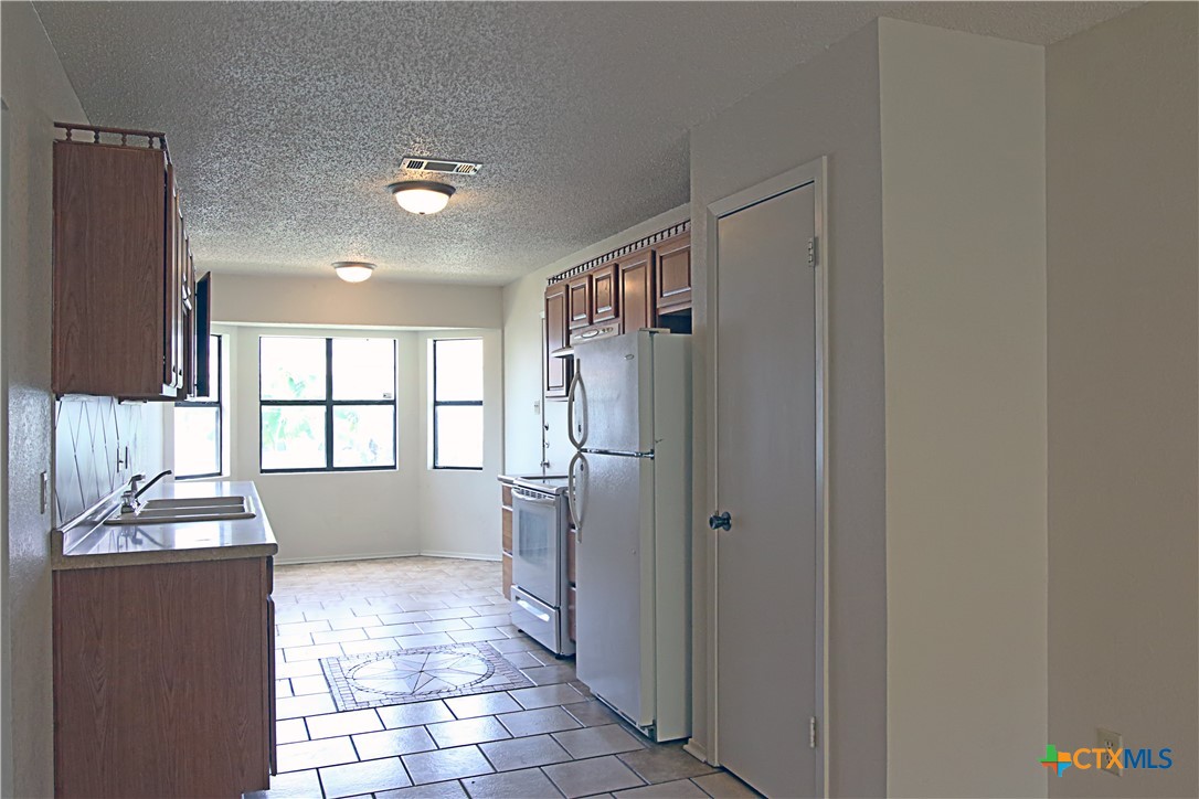2406 Boyd Avenue Killeen, TX 76543 - Photo 7 of 22 a view of a refrigerator and tub in a hall with an entryway