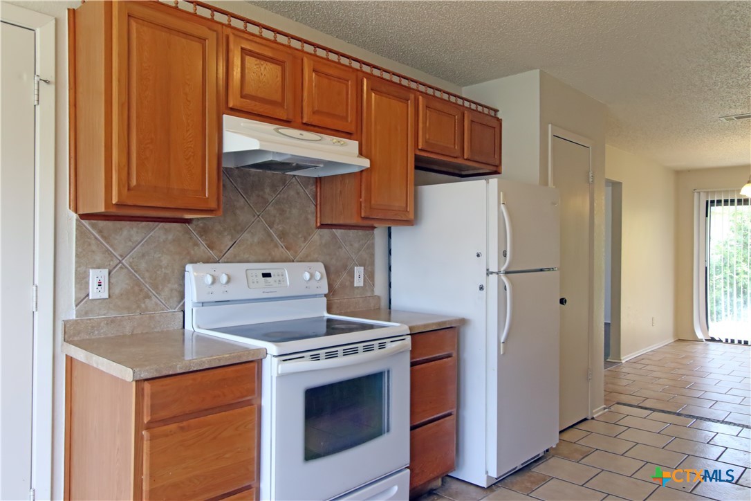 2406 Boyd Avenue Killeen, TX 76543 - Photo 9 of 22 a kitchen with stainless steel appliances granite countertop a stove and a refrigerator