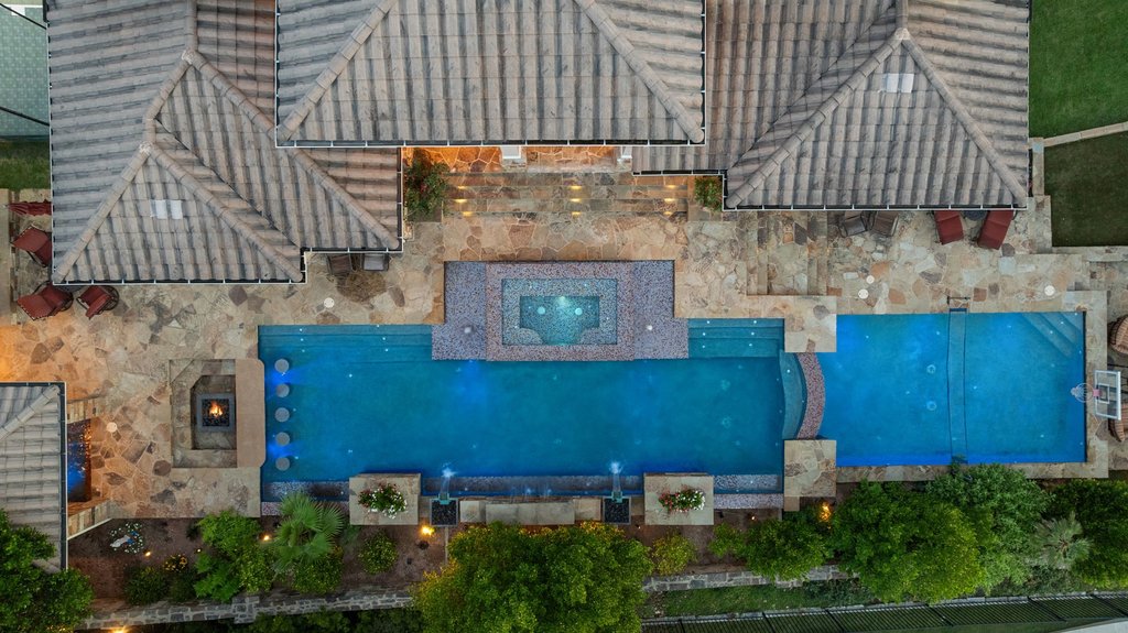 109 Largo Cove Austin, TX 78734 - Photo 3 of 40 An aerial perspective showcases the resort-style pool and spa, flanked by a fire pit and elegant stone paving.