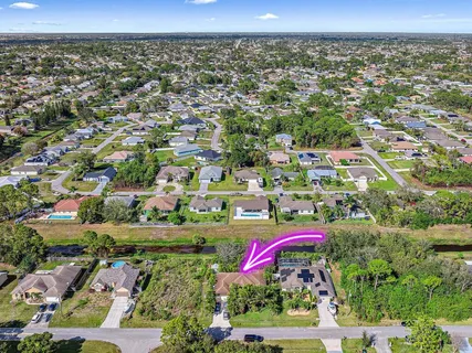 an aerial view of a house with a yard and large trees