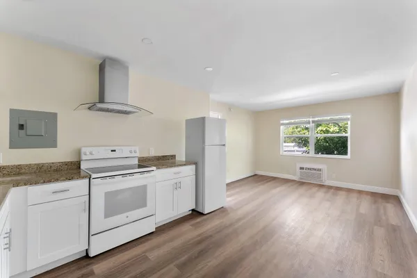a kitchen with a stove and a white wooden cabinets