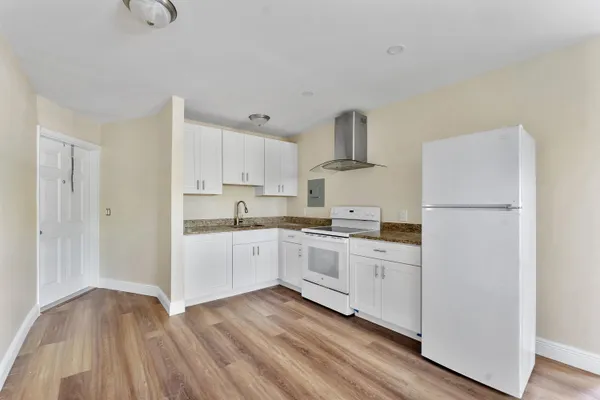 a kitchen with cabinets oven and a dishwasher with wooden floor