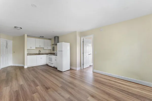 a view of kitchen with refrigerator cabinets and wooden floor
