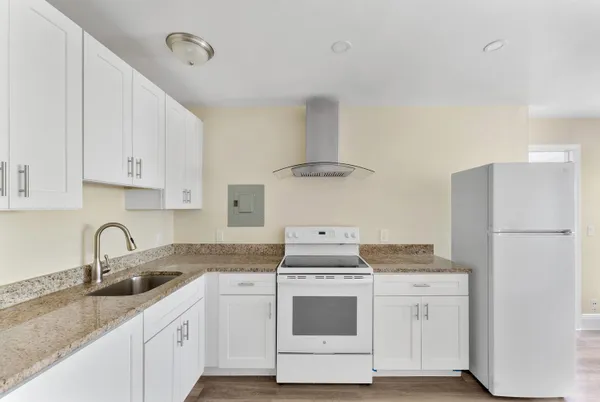 a kitchen with stainless steel appliances granite countertop a sink stove and refrigerator