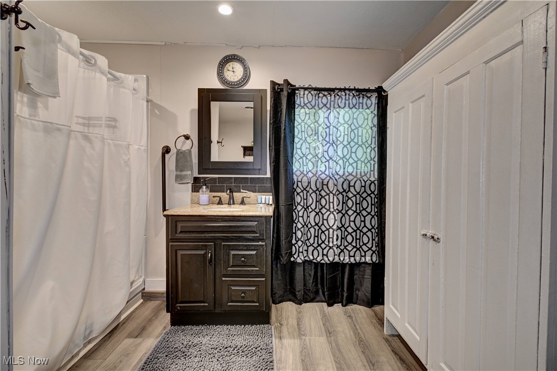 2227 Elk Road Southwest Carrollton, OH 44615 - Photo 32 of 40 Bathroom featuring vanity, light wood finished floors, a stall shower, and recessed lighting