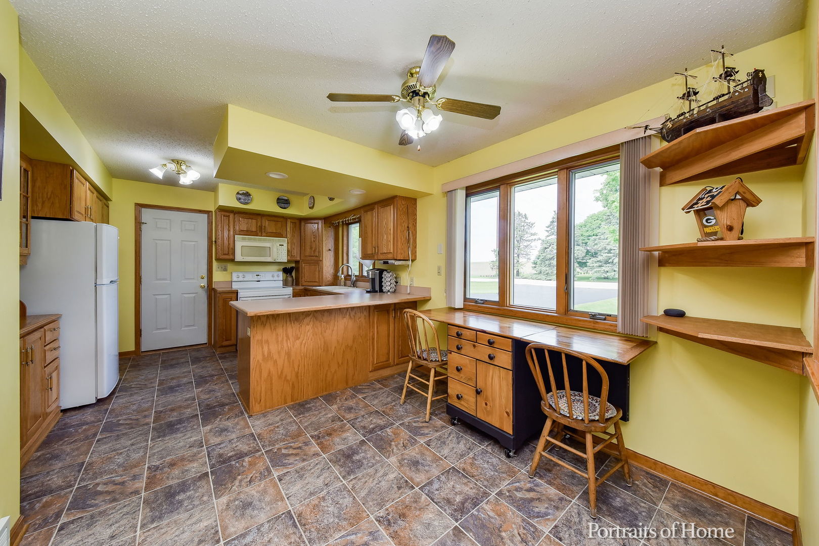 10522 Perry Road DeKalb, IL 60115 - Photo 6 of 27 a kitchen with stainless steel appliances kitchen island granite countertop a refrigerator a stove and a sink with cabinets