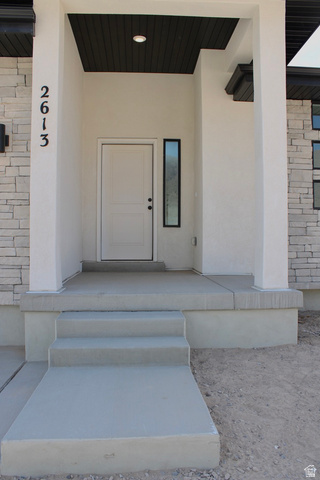 2613 Scarlet Road, Unit 258 Eagle Mountain, UT 84005 - Photo 3 of 32 Contemporary entryway featuring a white paneled door, a dark wood-finish ceiling, and a vertical frosted glass window