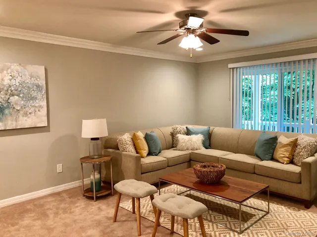a living room with furniture and a ceiling fan