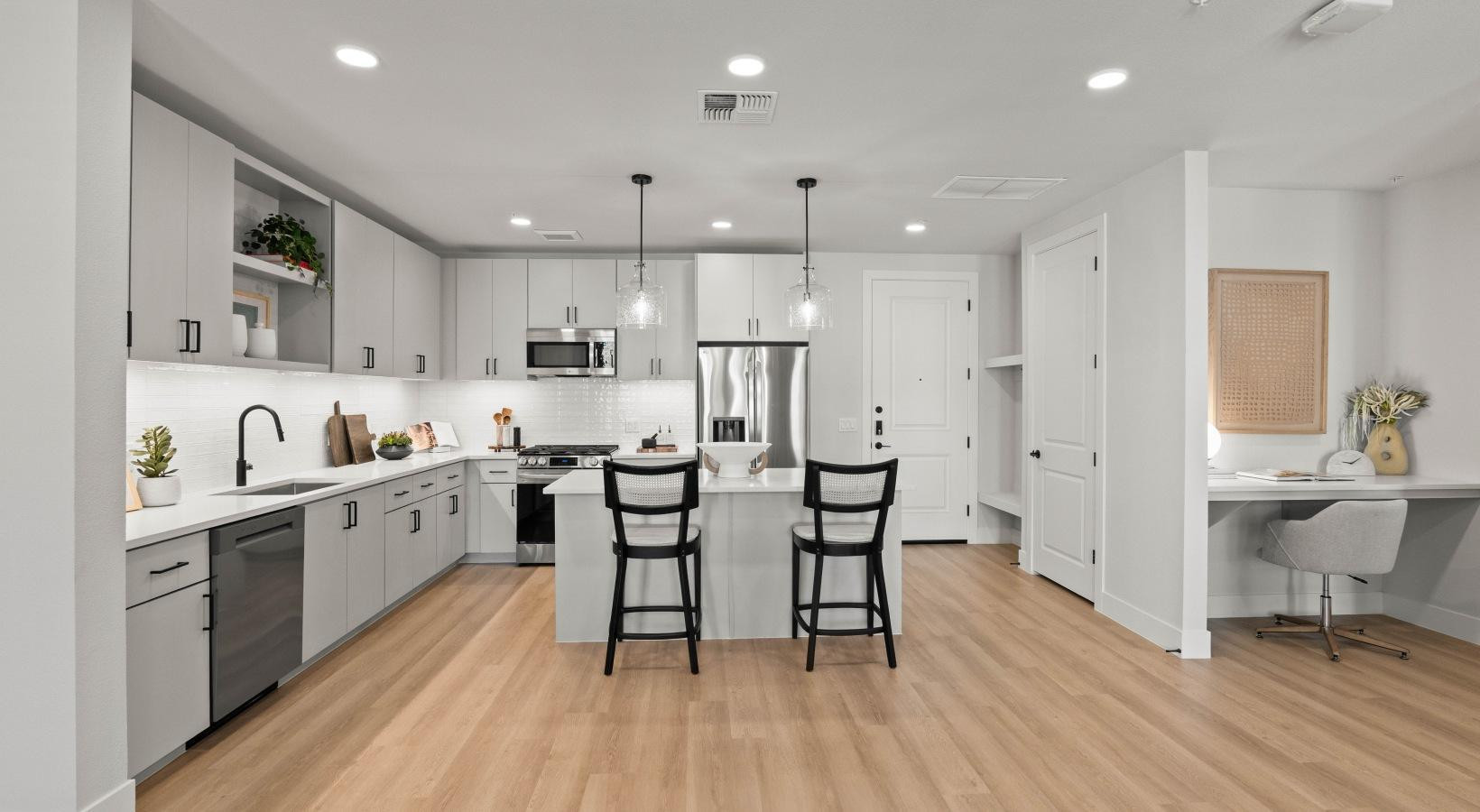 500 East Rivulon Boulevard, Unit C1 Gilbert, AZ 85297 - Photo 15 of 33 a large kitchen with cabinets wooden floor white stainless steel appliances and dining table