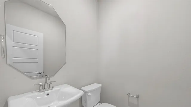a bathroom with a toilet a sink and mirror