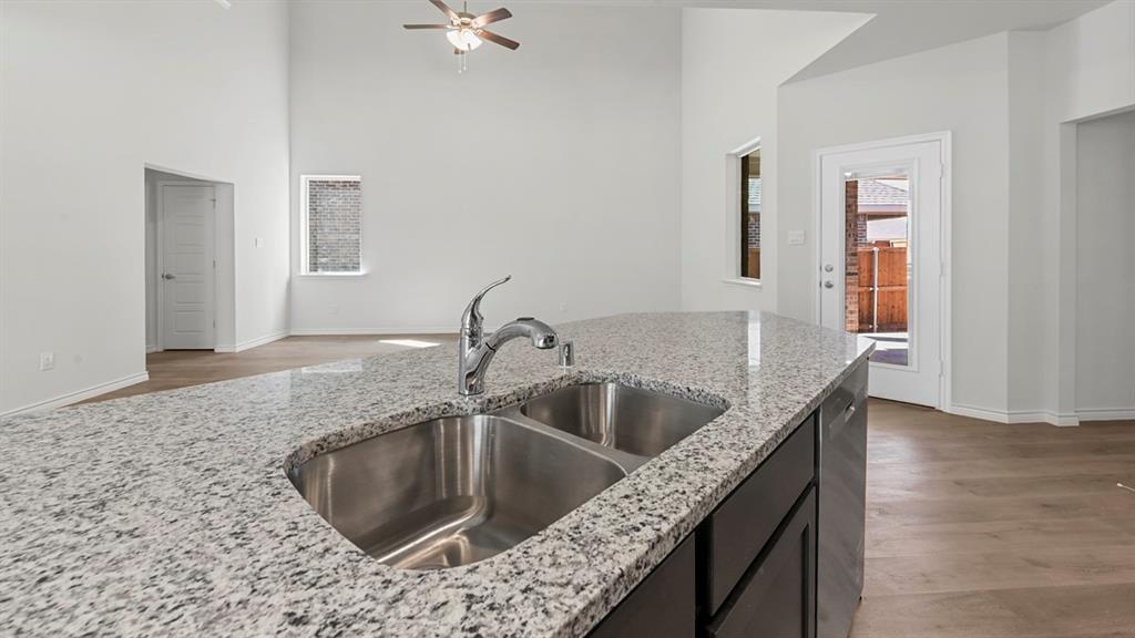 2328 Chloe Lane Anna, TX 75409 - Photo 22 of 37 a kitchen with a granite countertop sink and natural light
