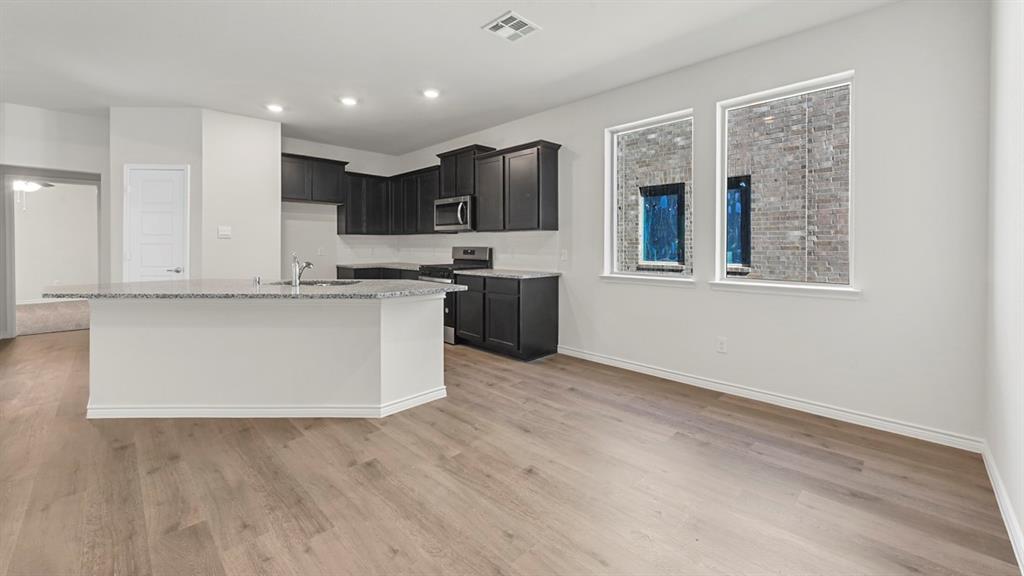 2328 Chloe Lane Anna, TX 75409 - Photo 27 of 37 a large kitchen with stainless steel appliances granite countertop a stove and a refrigerator