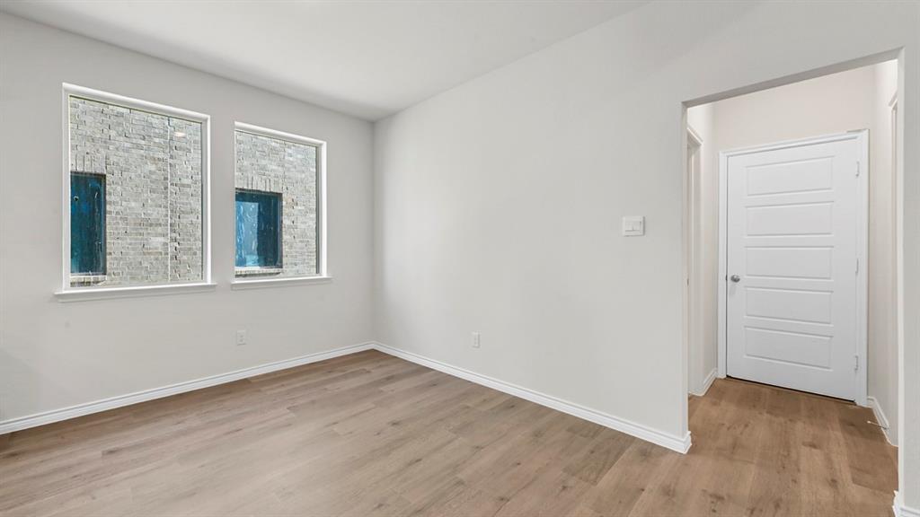 2328 Chloe Lane Anna, TX 75409 - Photo 30 of 37 a view of an empty room with wooden floor and a window