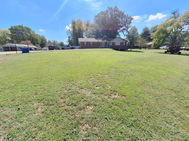 a view of a field with an trees in the background
