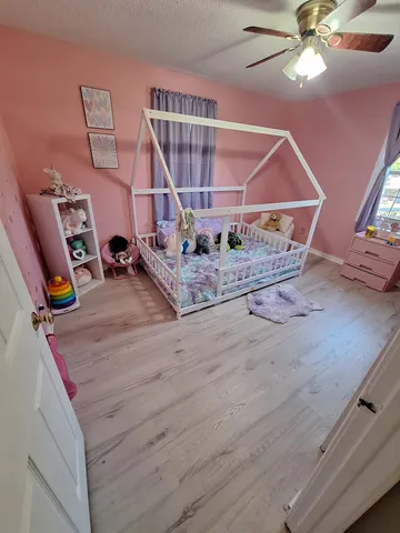 a room with gym equipment and wooden floor