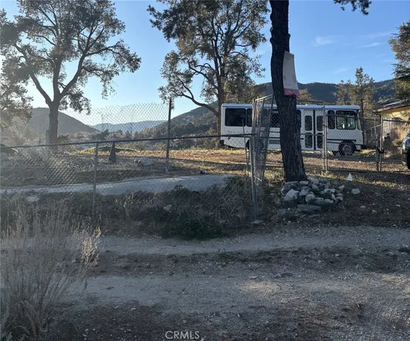 a view of a yard with wooden fence