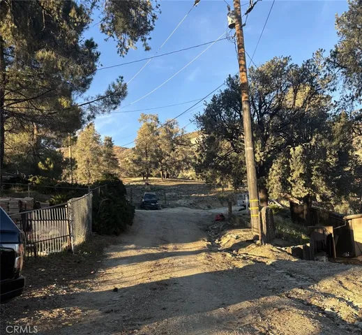 a view of backyard with wooden fence and trees