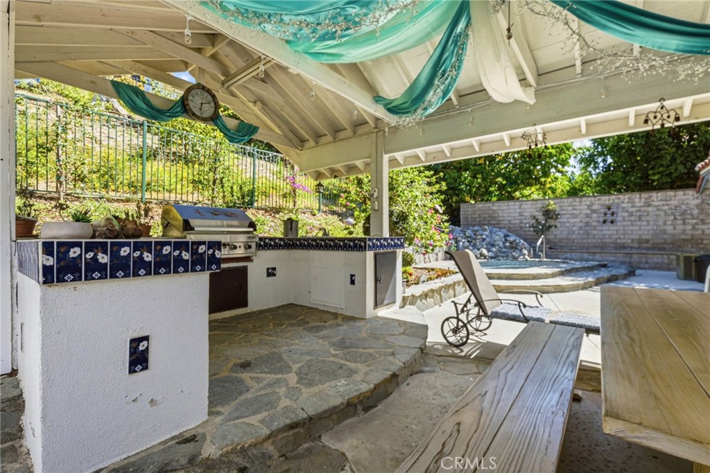 18233 Charlton Lane Porter Ranch, CA 91326 - Photo 25 of 40 a view of a patio with table and chairs with wooden floor and fence