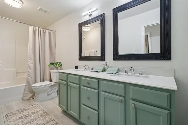 a bathroom with a granite countertop toilet sink and mirror