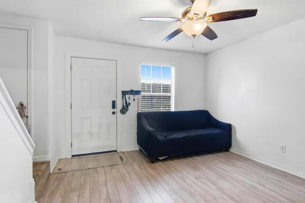a living room with couch and a ceiling fan