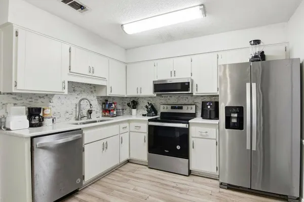 a kitchen with stainless steel appliances a refrigerator sink and cabinets