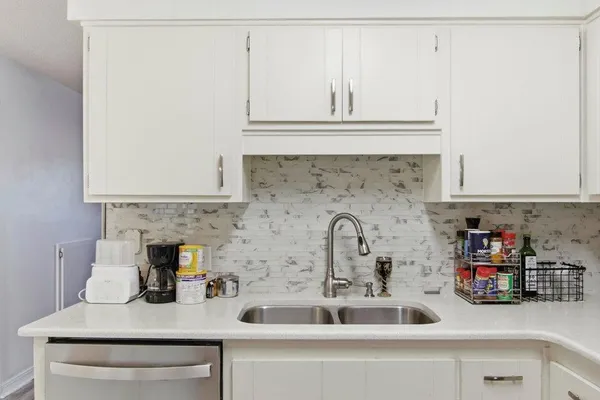 a kitchen with sink a microwave and cabinets