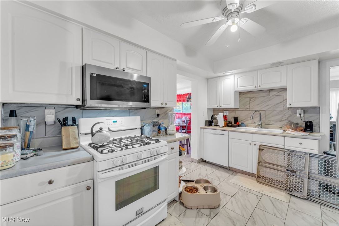 2123 North Taylor Road Cleveland Heights, OH 44112 - Photo 13 of 38 Kitchen with white appliances, white cabinetry, light countertops, light marble finish flooring, and ceiling fan