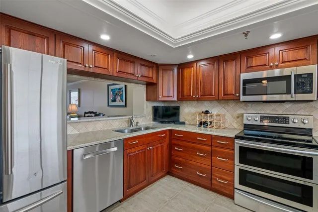 a kitchen with stainless steel appliances granite countertop a refrigerator and a stove top oven