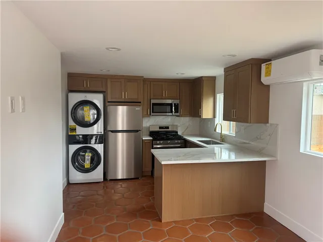 a kitchen with granite countertop a refrigerator stove and microwave