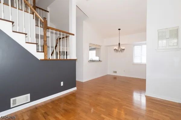a view of a room with wooden floor and chandelier