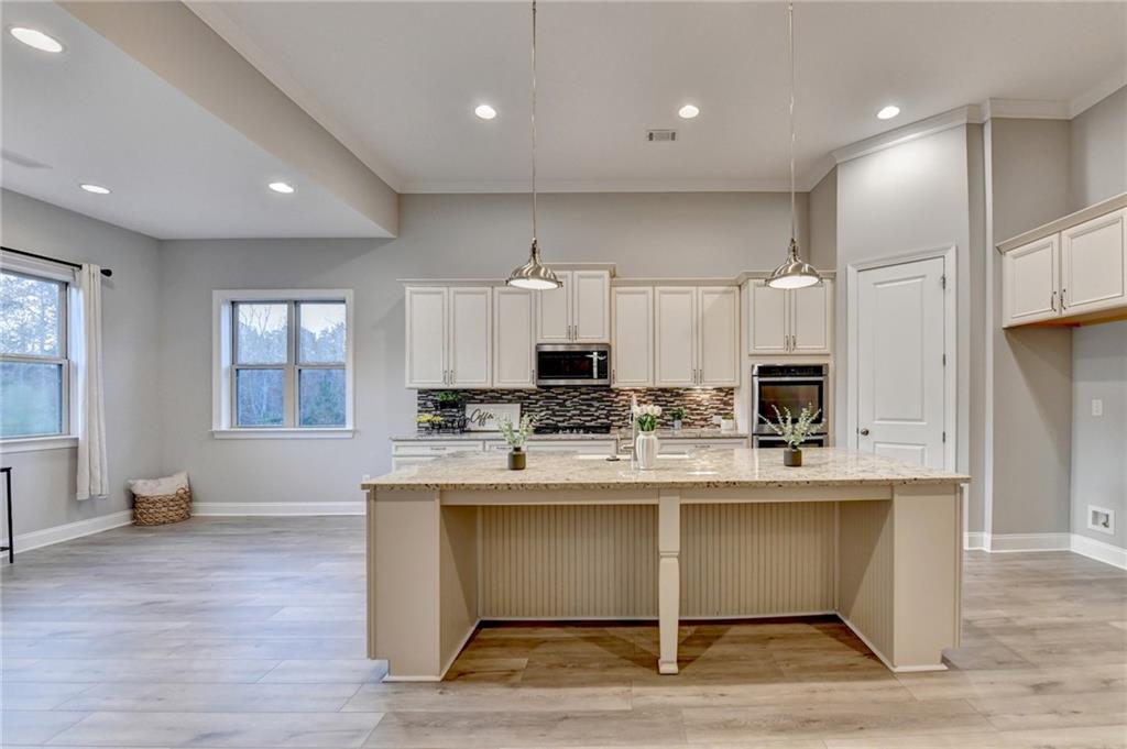 3907 Rustic Pine Lane Buford, GA 30518 - Photo 18 of 70 a large white kitchen with kitchen island a sink a stove and a refrigerator
