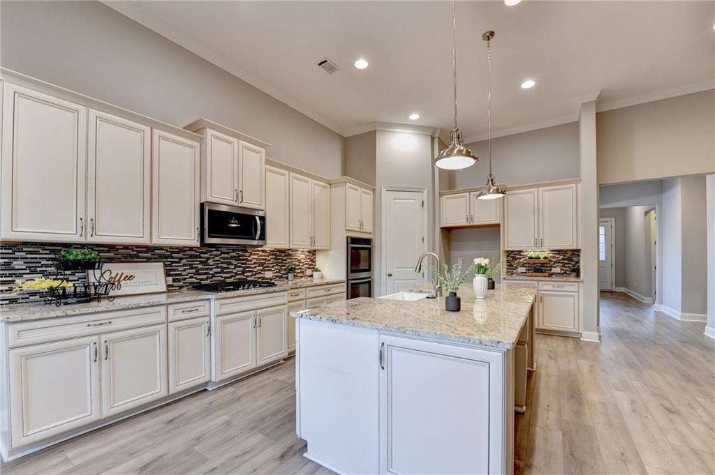 3907 Rustic Pine Lane Buford, GA 30518 - Photo 20 of 70 a kitchen with stainless steel appliances kitchen island a sink a stove and cabinets