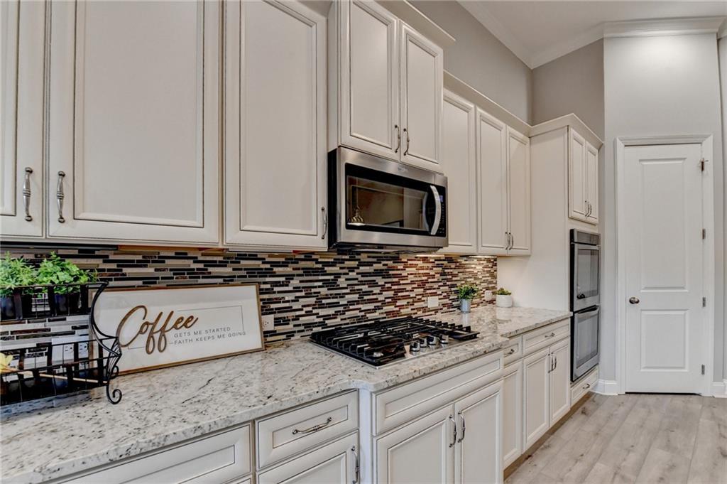3907 Rustic Pine Lane Buford, GA 30518 - Photo 23 of 70 a kitchen with granite countertop white cabinets and stainless steel appliances