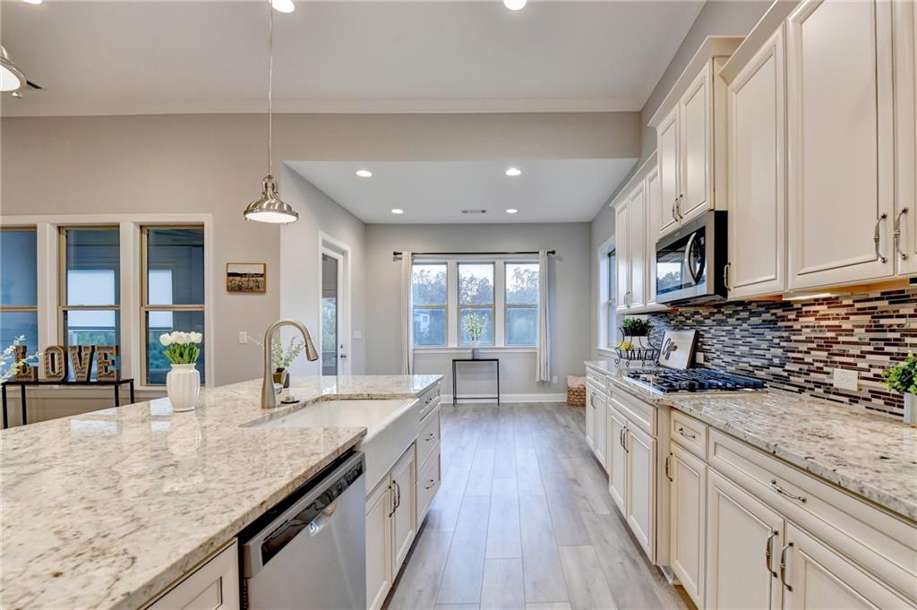 3907 Rustic Pine Lane Buford, GA 30518 - Photo 25 of 70 a kitchen with granite countertop a sink a counter space cabinets and stainless steel appliances