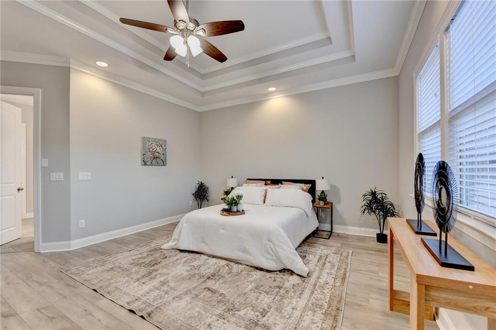 3907 Rustic Pine Lane Buford, GA 30518 - Photo 39 of 70 a bedroom with a bed chandelier and a flat screen tv