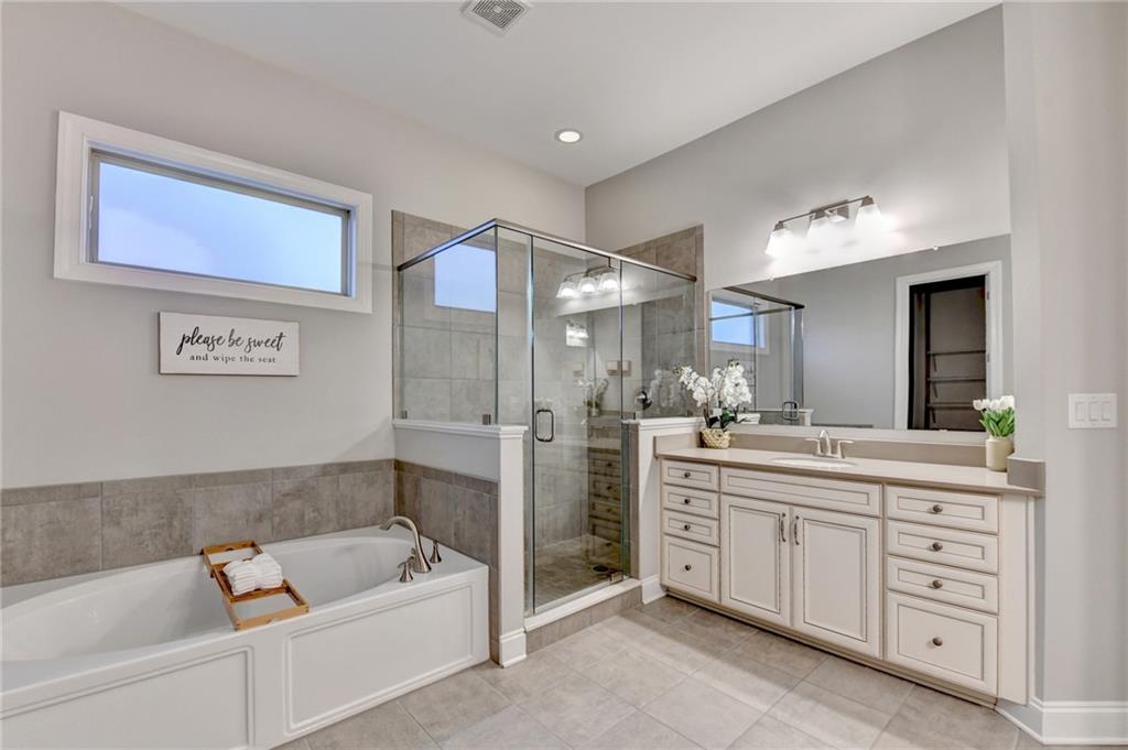 3907 Rustic Pine Lane Buford, GA 30518 - Photo 46 of 70 a bathroom with a tub sink and mirror