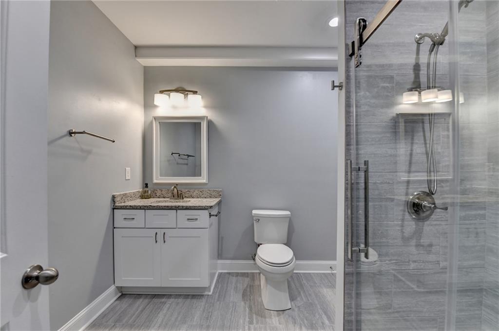 3907 Rustic Pine Lane Buford, GA 30518 - Photo 58 of 70 a bathroom with a toilet a sink and shower