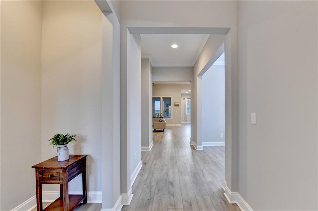 3907 Rustic Pine Lane Buford, GA 30518 - Photo 6 of 70 a view of a hallway with wooden floor and a potted plant