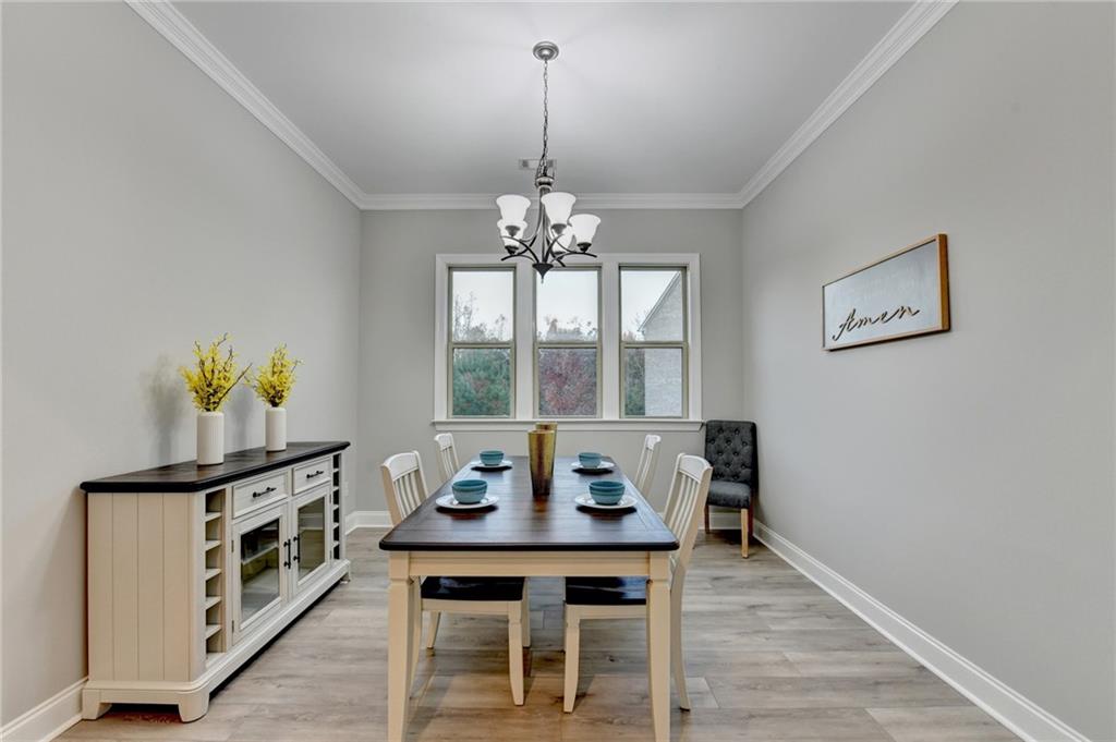 3907 Rustic Pine Lane Buford, GA 30518 - Photo 8 of 70 a view of a dining room with furniture a chandelier and wooden floor