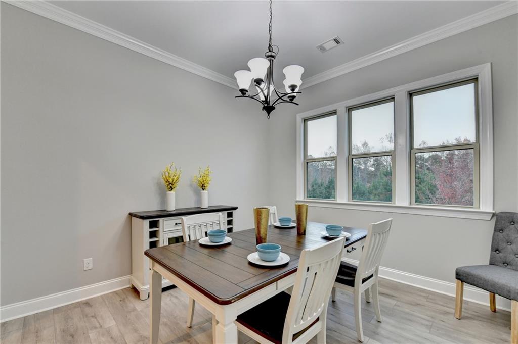 3907 Rustic Pine Lane Buford, GA 30518 - Photo 9 of 70 a view of a dining room with furniture a chandelier and wooden floor