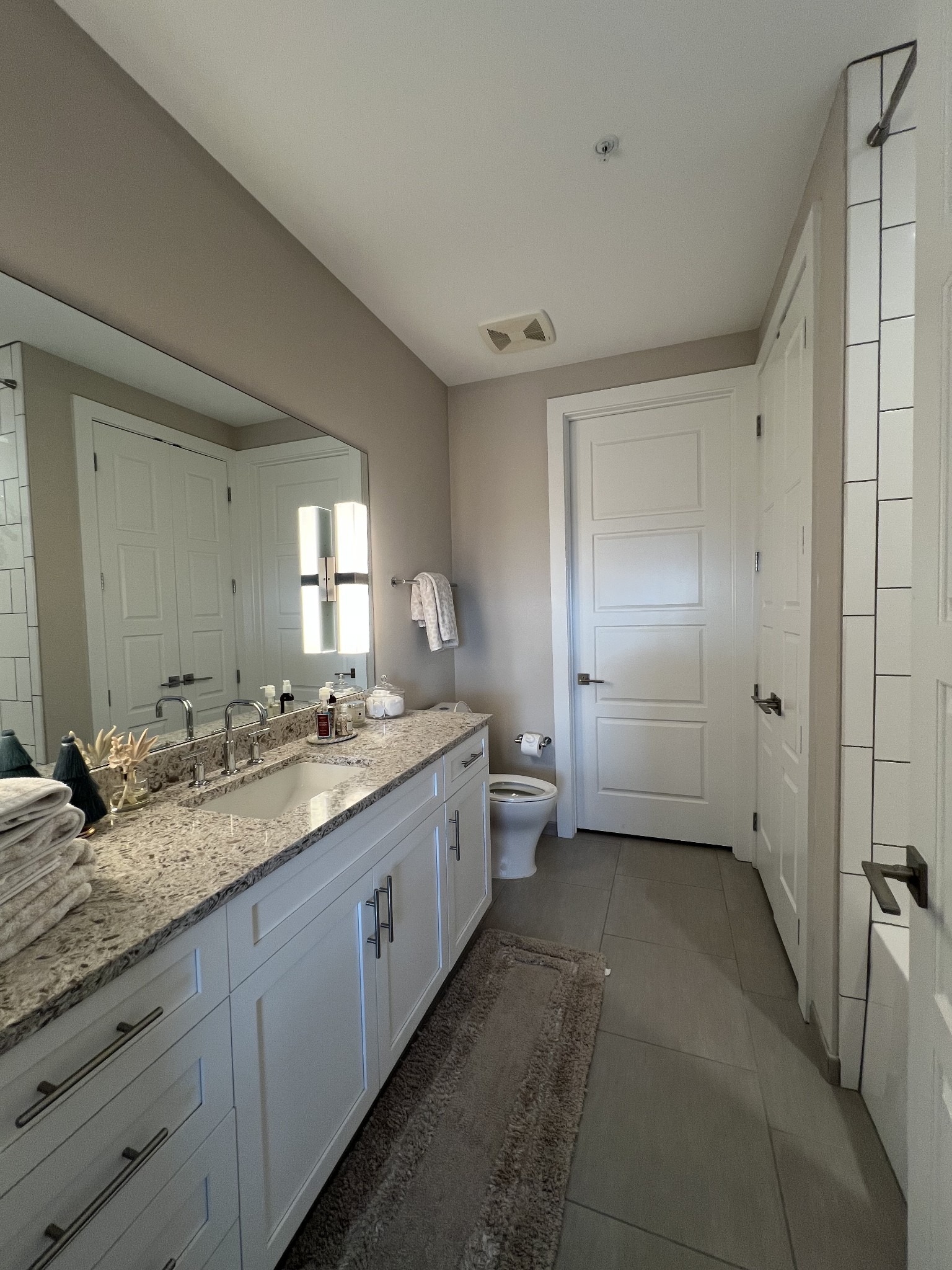 20 Rutledge Street, Unit 704 Nashville, TN 37210 - Photo 21 of 40 a bathroom with a granite countertop sink mirror and toilet