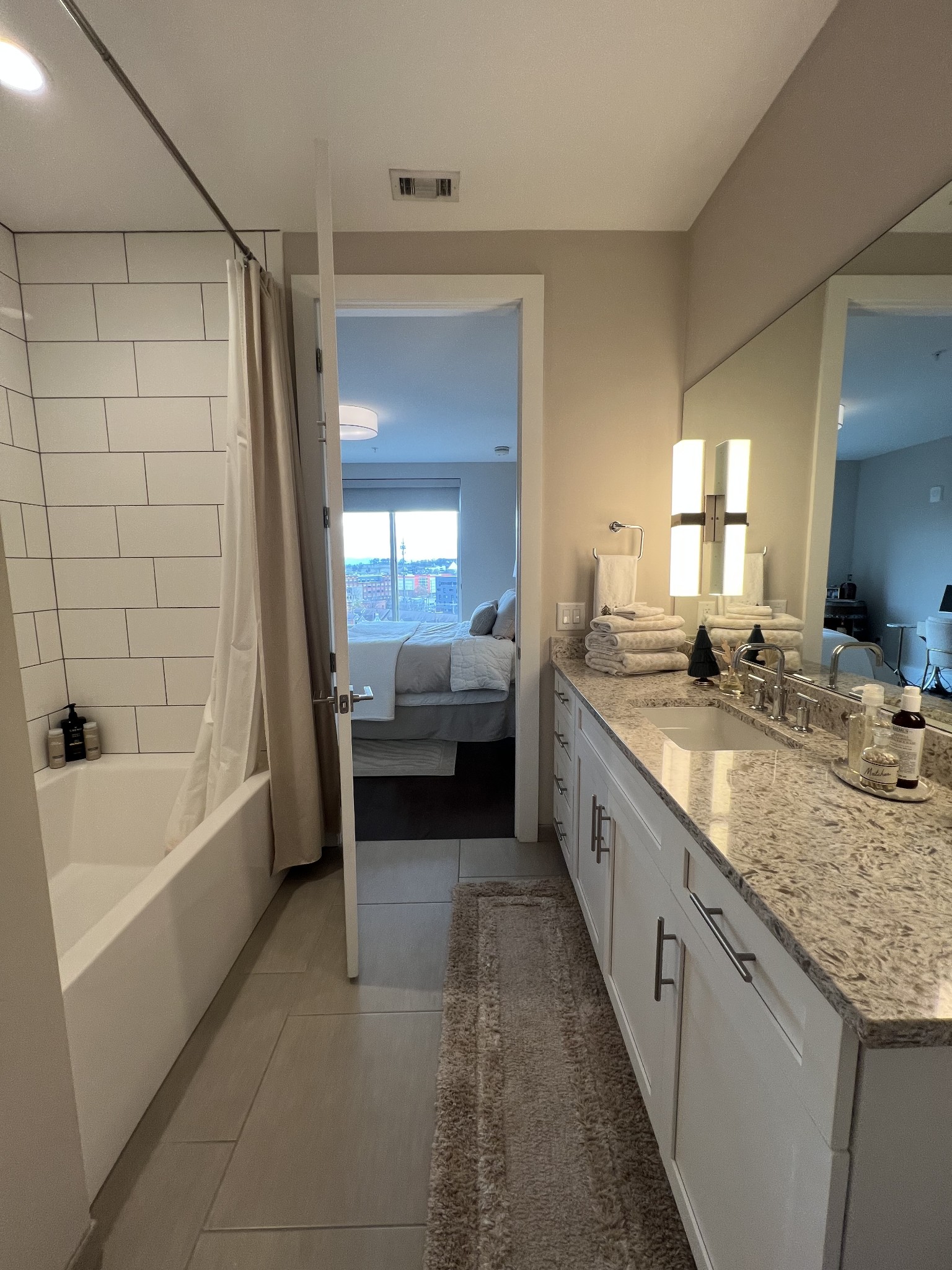20 Rutledge Street, Unit 704 Nashville, TN 37210 - Photo 23 of 40 a large bathroom with a granite countertop tub double vanity sink and a large mirror