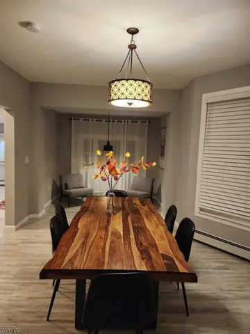 a room with wooden floor pool table and windows
