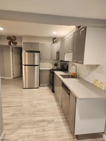 a kitchen with a sink a refrigerator and a stove top oven