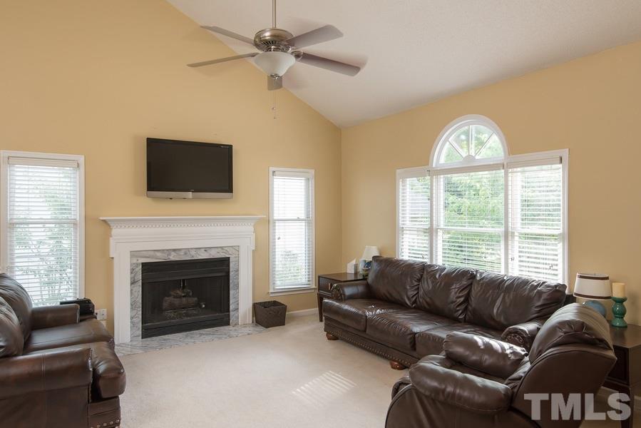 12220 Jarden Court Raleigh, NC 27613 - Photo 14 of 17 a living room with furniture a fireplace and a flat screen tv