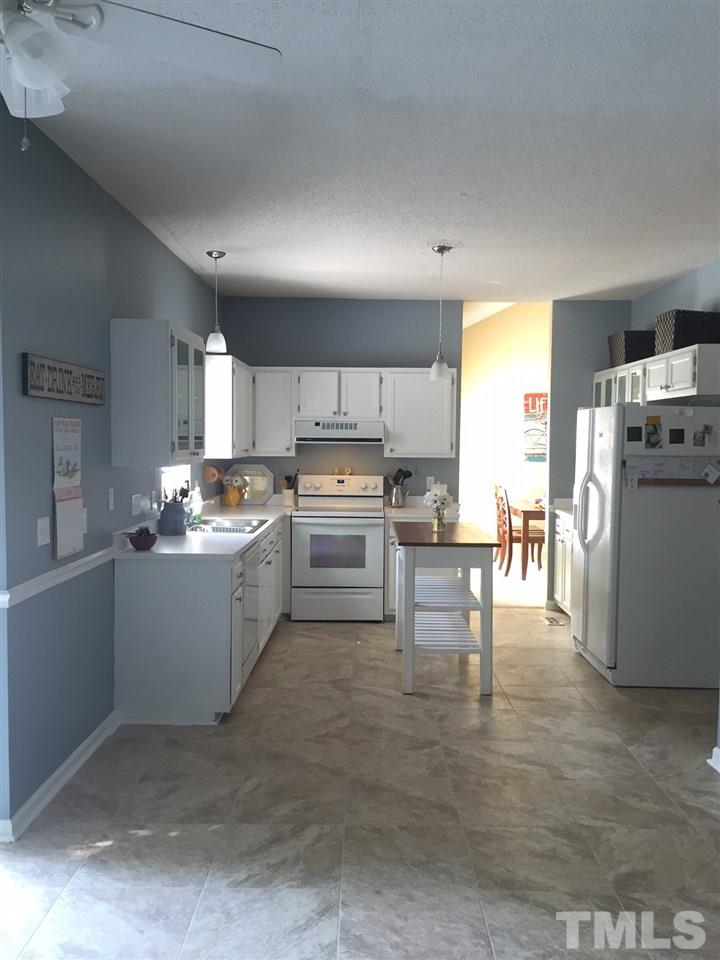 12220 Jarden Court Raleigh, NC 27613 - Photo 7 of 17 a kitchen with white cabinets and stainless steel appliances