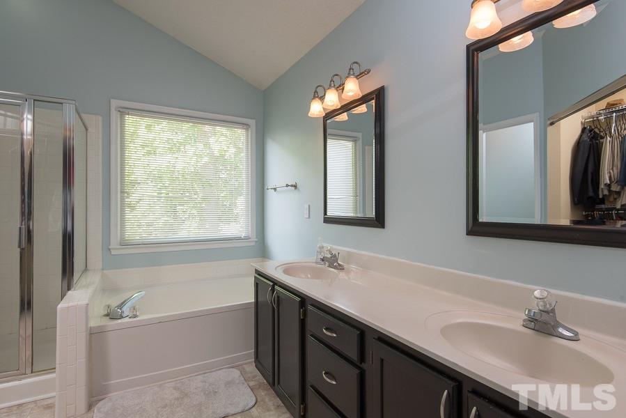 12220 Jarden Court Raleigh, NC 27613 - Photo 9 of 17 a bathroom with a tub a sink and a mirror