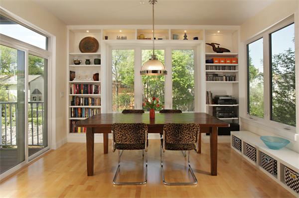 a dining room with stainless steel appliances granite countertop a table chairs and a large window
